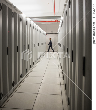 Technician walking in server hallway Technician walking in server hallway 12156483