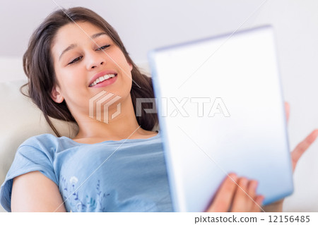 Pretty brunette using her tablet pc on the couch Pretty brunette using her tablet pc on the couch 12156485