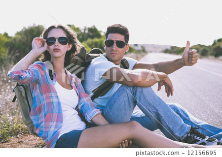 Couple hitchhiking on countryside road 12156695