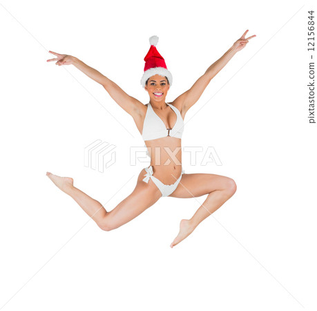 Fit girl in bikini smiling at camera wearing santa hat 12156844