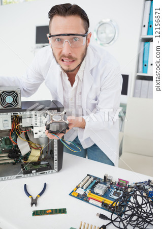 Stressed computer engineer showing broken fan Stressed computer engineer showing broken fan 12156871