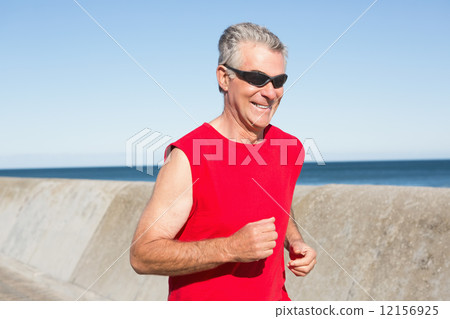 Active senior man jogging on the pier 12156925