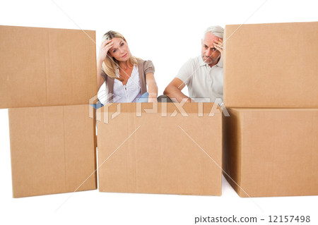 Stressed couple looking at moving boxes Stressed couple looking at moving boxes 12157498