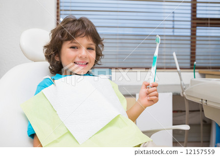 Little boy in dentists chair holding toothrbrush 12157559