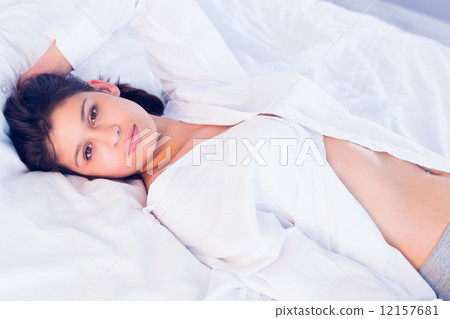 Sexy brunette smiling at camera on bed Sexy brunette smiling at camera on bed 12157681