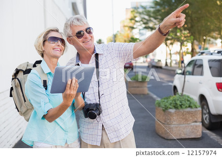 Happy tourist couple using tablet in the city Happy tourist couple using tablet in the city 12157974