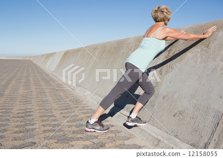 Active senior woman stretching on the pier 12158055
