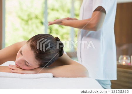 Beautiful woman lying on massage table at spa center 12158255