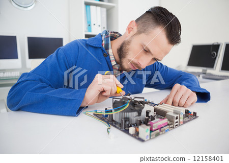 Computer engineer working on cpu with screwdriver Computer engineer working on cpu with screwdriver 12158401