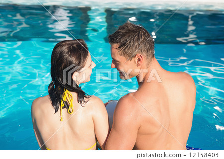 Smiling young couple in swimming pool 12158403