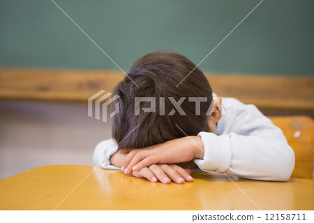 Sleepy pupil napping at desk in classroom Sleepy pupil napping at desk in classroom 12158711