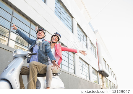 Happy senior couple riding a moped 12159047