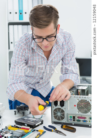 Young technician working on broken computer 12159048