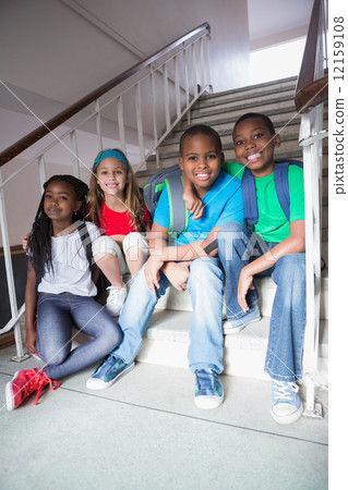 Cute pupils smiling at camera on the stairs Cute pupils smiling at camera on the stairs 12159108