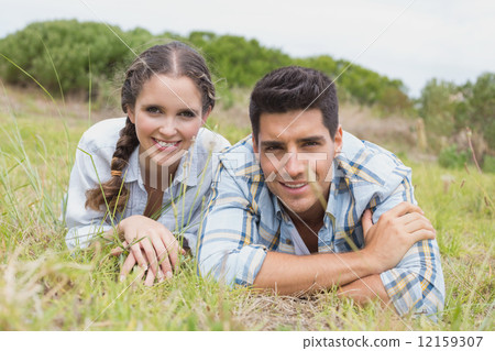 Couple lying on countryside landscape 12159307