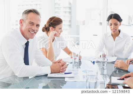 Businessman smiling in a meeting Businessman smiling in a meeting 12159843