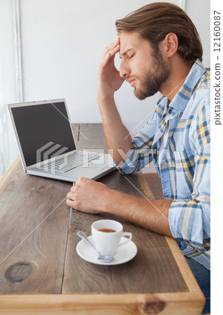 Casual man using laptop having coffee 12160087