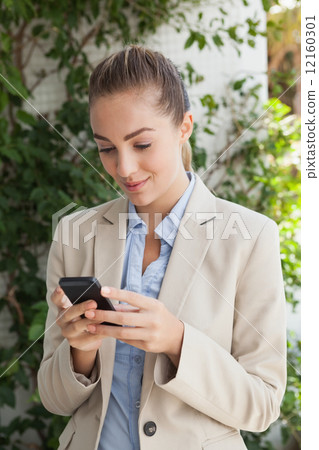 Beautiful businesswoman texting on phone Beautiful businesswoman texting on phone 12160301