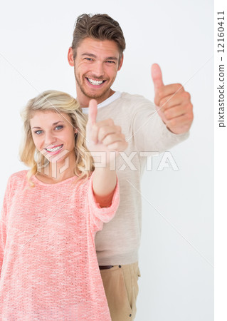Happy young couple gesturing thumbs up Happy young couple gesturing thumbs up 12160411