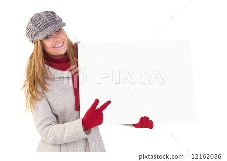 Happy blonde in winter clothes showing card 12162086