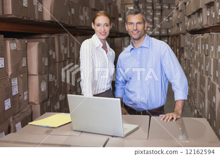 Warehouse team working together on laptop Warehouse team working together on laptop 12162594