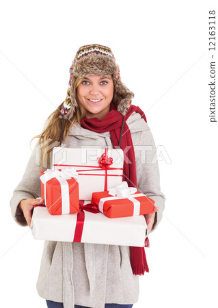 Happy blonde in winter clothes holding gifts Happy blonde in winter clothes holding gifts 12163118
