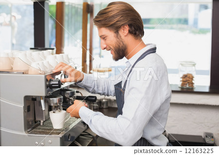 Handsome barista making a cup of coffee 12163225
