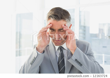 Businessman suffering from a headache Businessman suffering from a headache 12163724