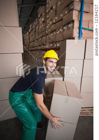 Warehouse worker loading up a pallet 12164217