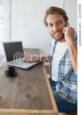 Stock Photo: Casual man using laptop having coffee