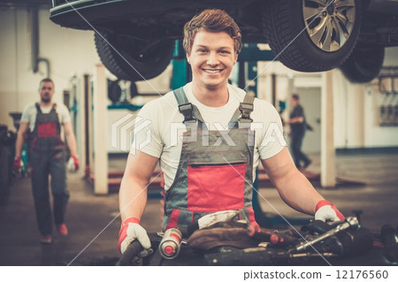 Young mechanic with tools in a car workshop 12176560