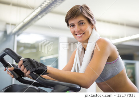 Fit smiling woman working out on the exercise bike