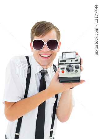 Geeky hipster holding a retro camera 12177444