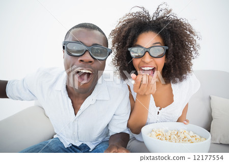 Couple sitting on couch together watching 3d movie 12177554