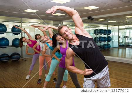 Fitness class led by handsome instructor 12177642