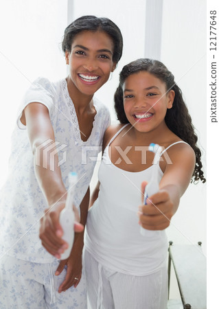 Pretty mother brushing her teeth with her daughter 12177648