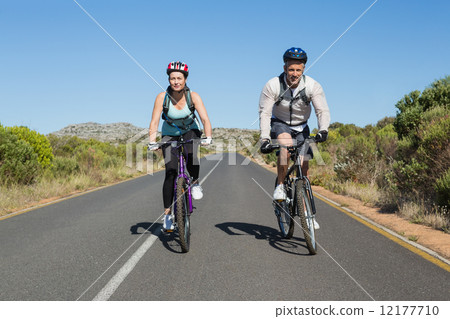 圖庫照片: active couple going for a bike ride in the countryside