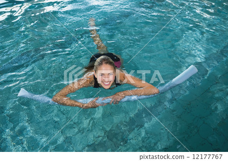 Fit blonde swimming with foam roller 12177767