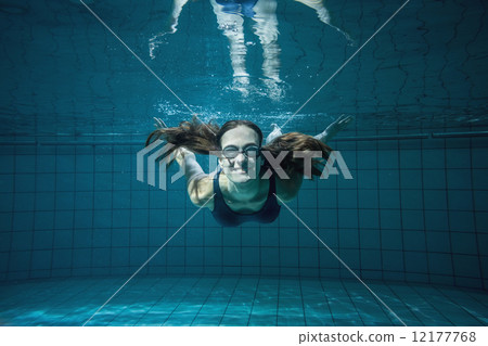 Athletic swimmer smiling at camera underwater 12177768