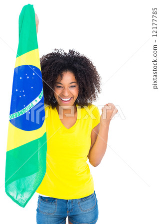 Pretty girl in yellow tshirt holding brazilian flag cheering at Pretty girl in yellow tshirt holding brazilian flag cheering at 12177785