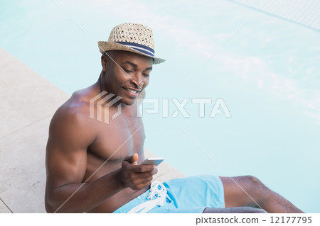 Handsome shirtless man texting on phone poolside Handsome shirtless man texting on phone poolside 12177795
