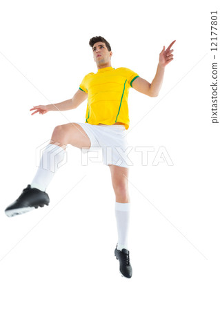 Football player in yellow jersey kicking 12177801