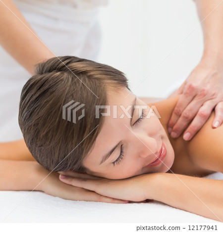 Attractive woman receiving shoulder massage at spa center 12177941