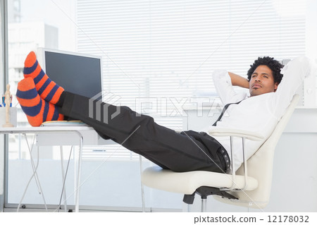 Businessman relaxing in his swivel chair with feet up 12178032