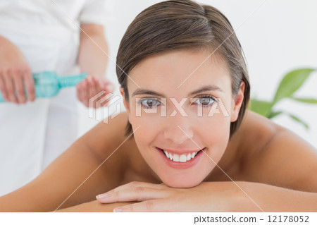 Attractive woman getting massage oil on her back Attractive woman getting massage oil on her back 12178052