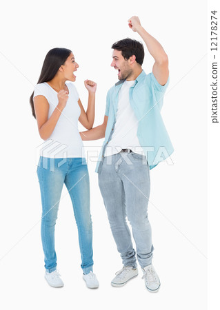 Happy casual couple cheering together 12178274