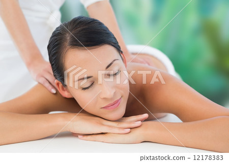 Beautiful brunette enjoying a shoulder massage Beautiful brunette enjoying a shoulder massage 12178383