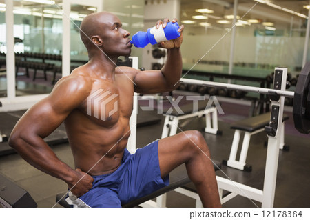 Muscular man drinking energy drink in gym Muscular man drinking energy drink in gym 12178384