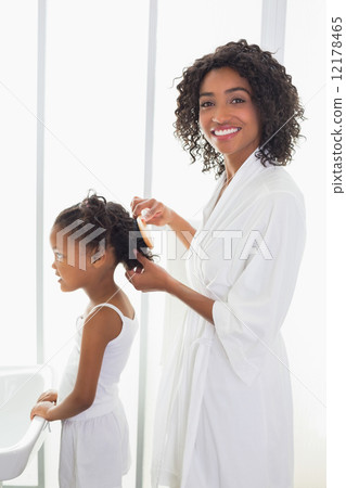 Pretty mother brushing her daughters hair 12178465