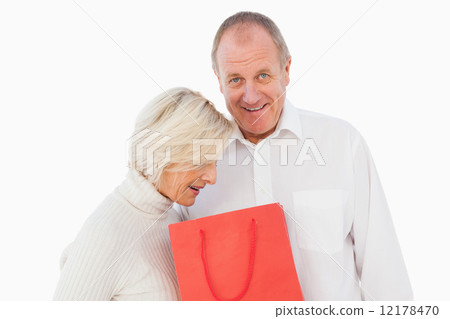 Older couple holding red gift bag Older couple holding red gift bag 12178470